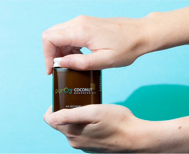 Hands holding a jar of ozonated oil